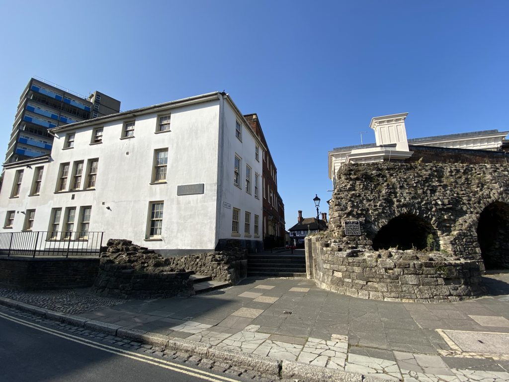 The site of Southampton Castle's gate. The partially-reconstructed bases of the two drum towers can be seen either side of the gate, and the tower block that marks the site of the castle can be seen on the left.